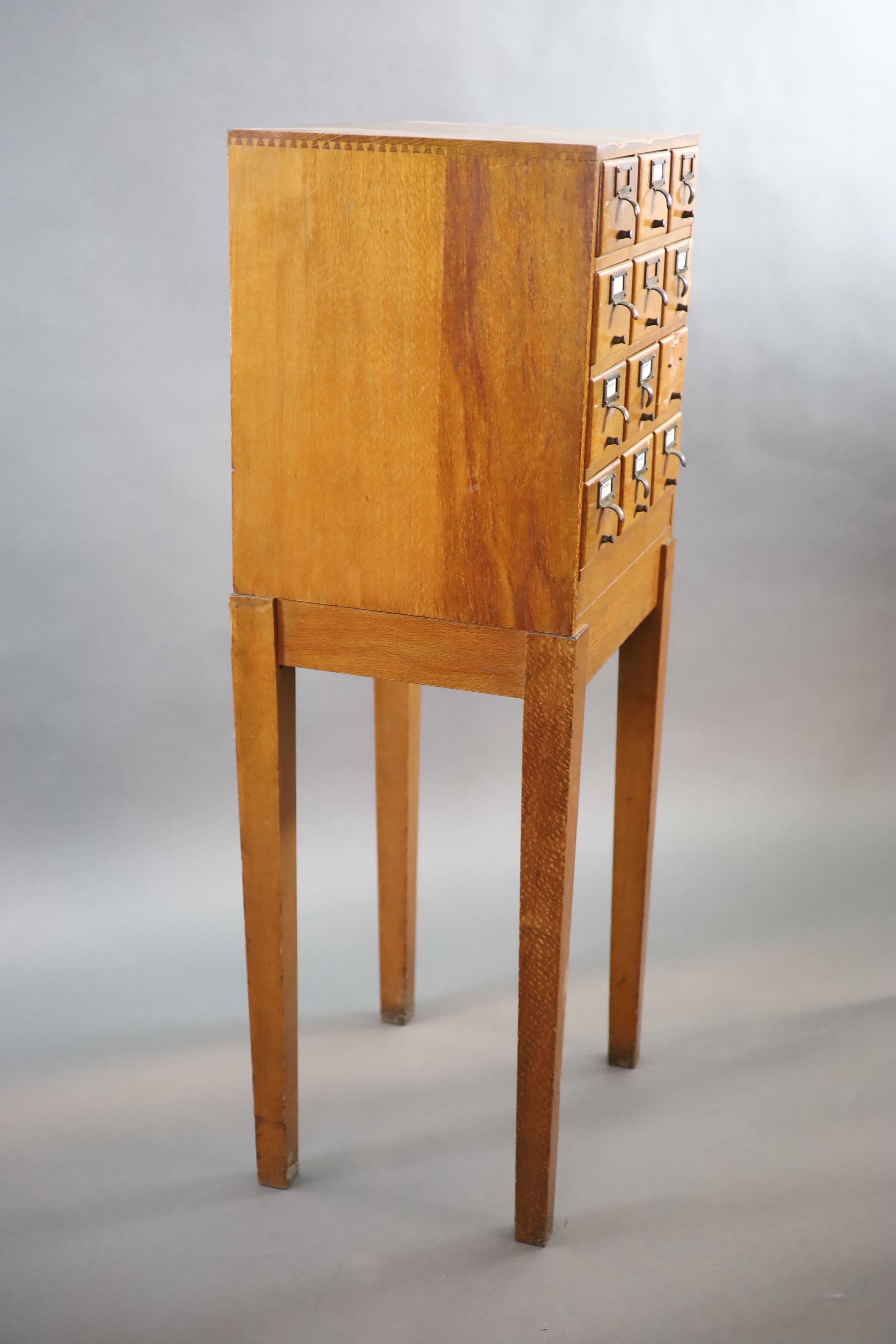 An early 20th century golden oak filing chest on stand, fitted twelve drawers, width 50cm depth 41cm height 131cm